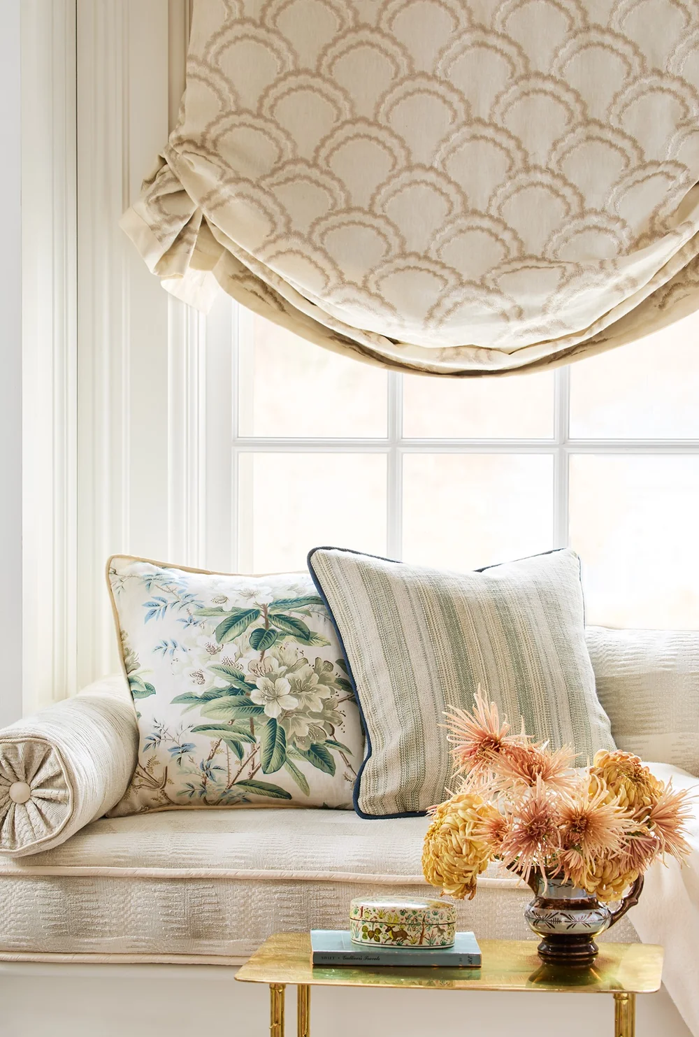 Patterned Roman shade and cushions in a Cowtan & Tout window setting