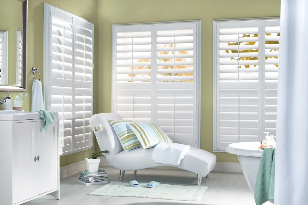 White plantation shutters in a bright Elegant Window Fashions interior