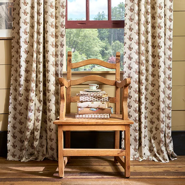 Patterned Lacefield drapery framing a warm wood accent chair